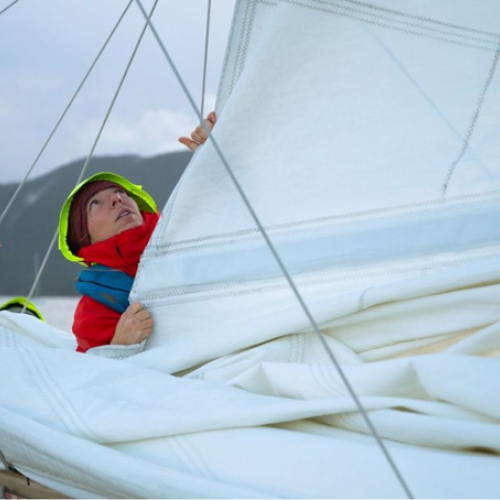 This is a photo of the skipper helping the mainsail up before a windy day of racing. 